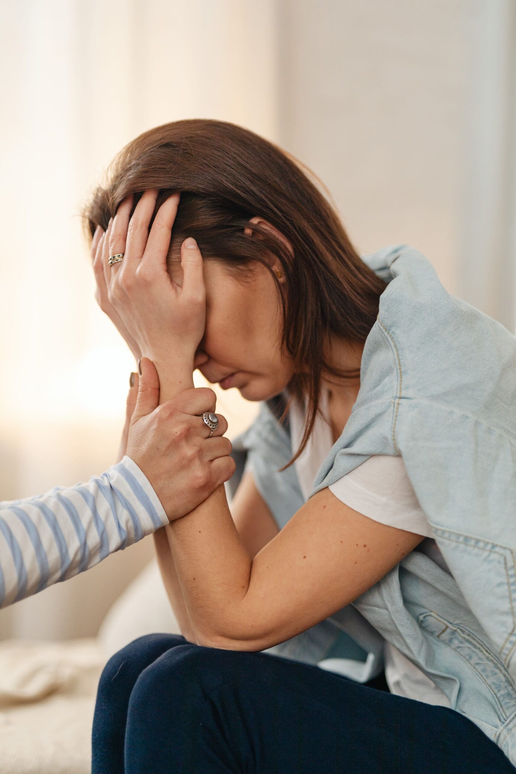 Woman with hand over face in distress